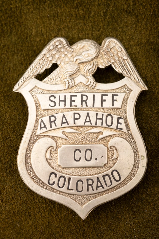Vintage Shield Badge with Eagle Crest marked “SHERIFF/ ARAPAHOE/ CO./ COLORADO?? with black soft: Vintage Shield Badge with Eagle Crest marked “SHERIFF/ ARAPAHOE/ CO./ COLORADO” with black soft enamel lettering. Nice patina and wear with beautiful detail on eagle. Measures 2 ½&rdquo