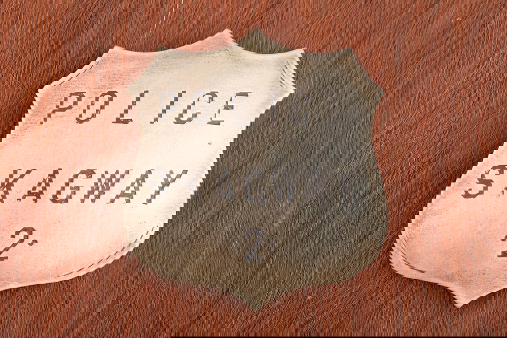 Vintage Shield Badge marked “POLICE SKAGWAY 2??, minor hand engraving with lots of great patina,: Vintage Shield Badge marked “POLICE SKAGWAY 2”, minor hand engraving with lots of great patina, measures 2 3/8” T x 2 ¼” W, has strong pin with tunnel catch. The Lee Hutches