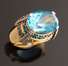 Ladies 18kt yellow gold custom oval Blue Topaz ring containing 46 round brilliant cut blue diamonds.