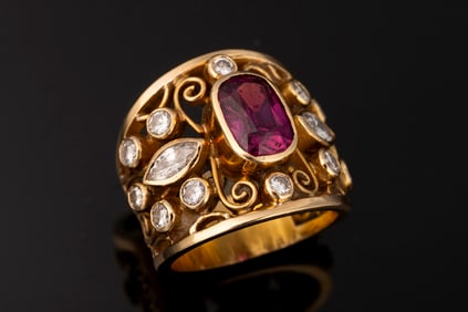 Ladies 18kt yellow gold open filigree band containing one cushion cut fine quality ruby (6.6 mm x