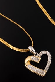 Ladies 14kt yellow gold 1.60ctw baguette diamond heart with 14kt white gold "70". Weighing 8.5