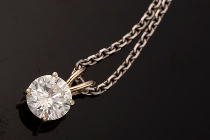 One Ladies 14kt W/G four prong pendant containing a 1.12ct round brilliant cut diamond possessing I