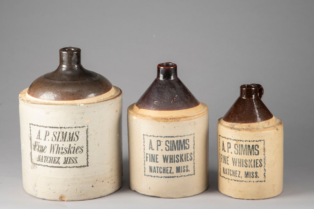 THIS LOT WILL BE SOLD THREE (3) TIMES YOUR BID, MEANING YOUR FINAL BID WILL BE MULTIPLIED THREE (3): THIS LOT WILL BE SOLD THREE (3) TIMES YOUR BID, MEANING YOUR FINAL BID WILL BE MULTIPLIED THREE (3) TIMES. Collection of three antique Crock Jugs advertising "A.P. Simms/Fine Whiskies/Natchez, Miss." 