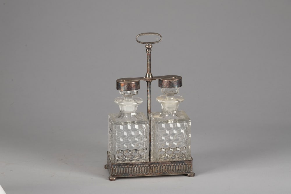 A vintage, fine quality silver and glass Tantalus (portable Bar) marked on base "Apollo Serial: A vintage, fine quality silver and glass Tantalus (portable Bar) marked on base "Apollo Serial Number 6075/2". Unique footed base with two 9" x 2 1/2" sq. whiskey bottles, in perfect condition. Area f