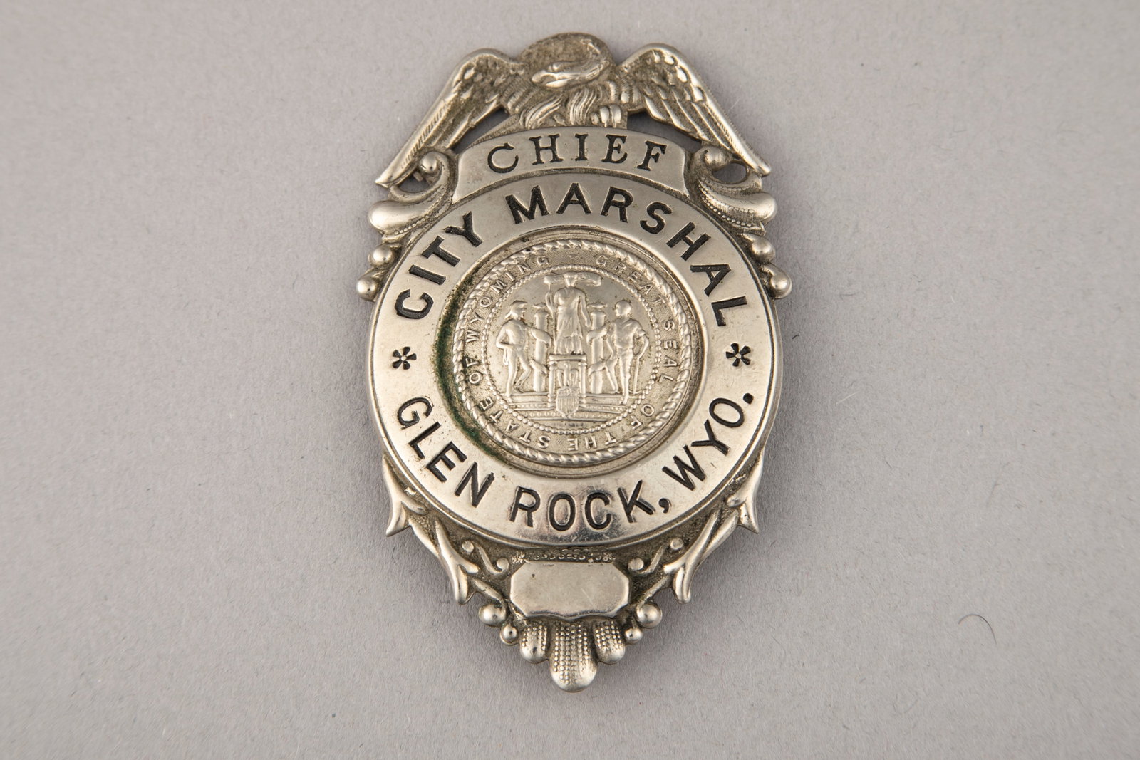 Vintage Shield Badge with eagle crest marked " Chief/City Marshal/Glen Rock, Wyo." and "Great Seal: Vintage Shield Badge with eagle crest marked " Chief/City Marshal/Glen Rock, Wyo." and "Great Seal of the State of Wyoming" in the center. No hallmark, has pin with fork catch and measures 3" T x 1 3/