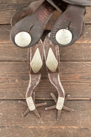 Pair of "Kelly Bros." marked single mounted Spurs with etched fixed buttons, sold with two-piece