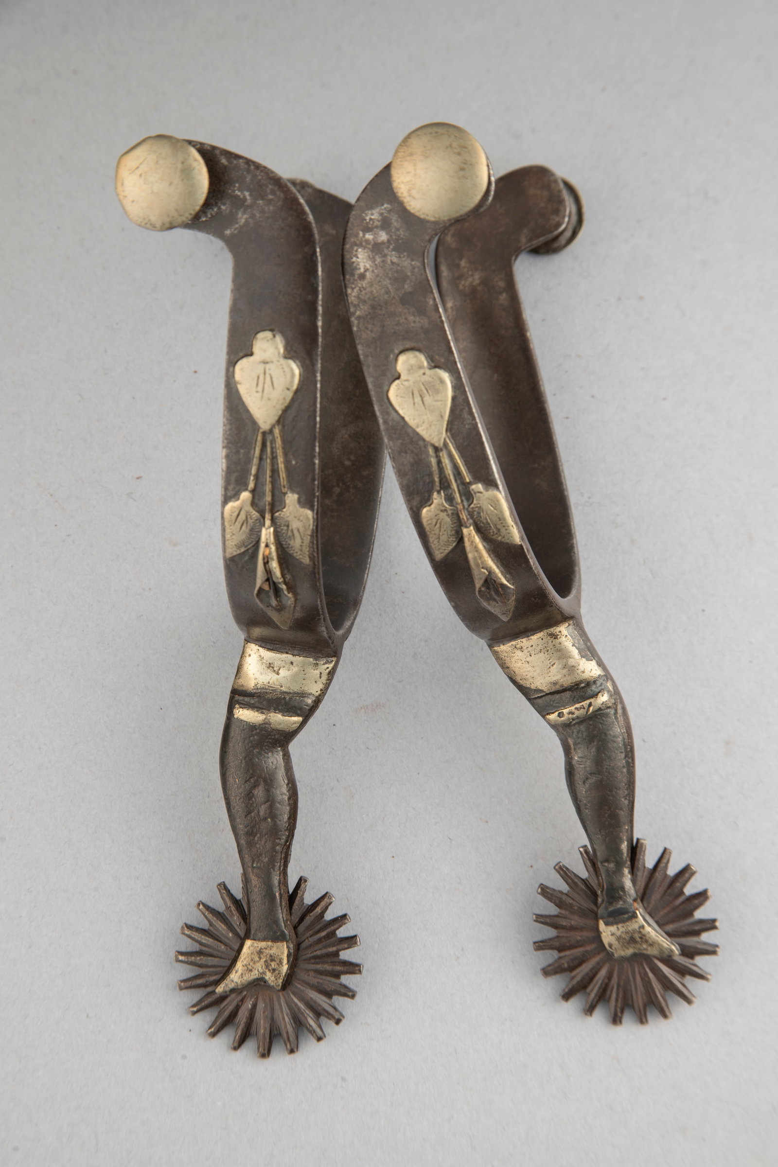Early pair of McChesney double mounted gal-leg Spurs with leaf and vine overlaid on heel bands.: Early pair of McChesney double mounted gal-leg Spurs with leaf and vine overlaid on heel bands. Maples Estate.
