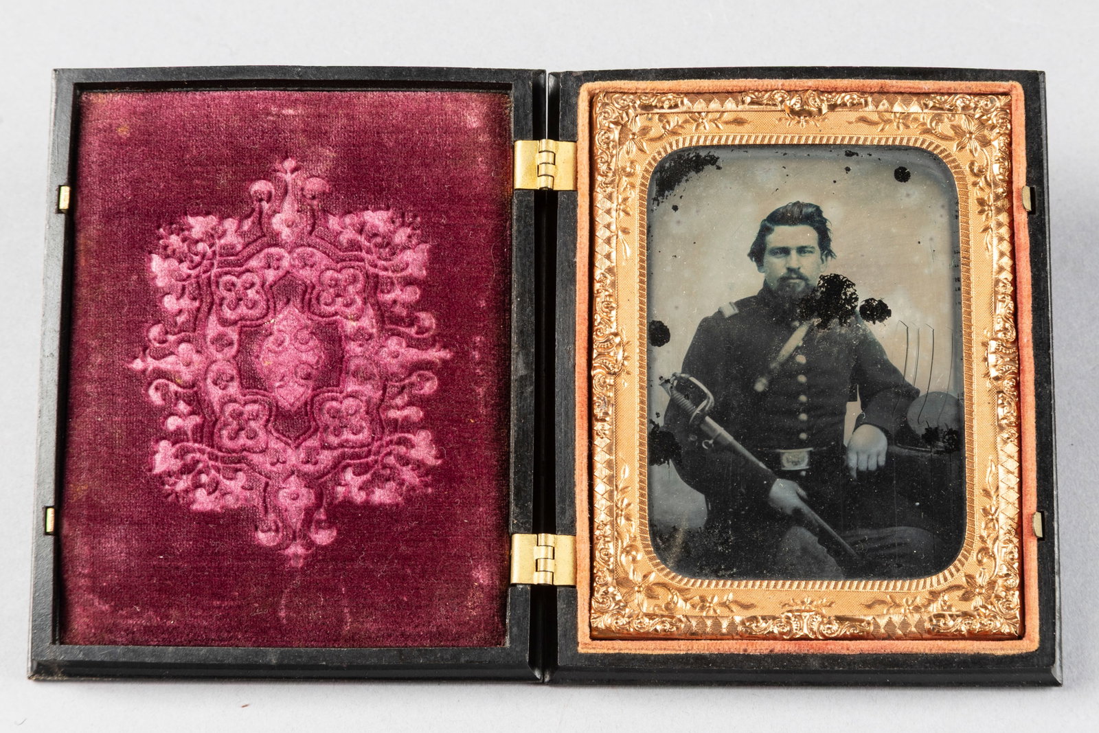 Cased Civil War Period Daguerreotype with soldier holding a sword in sheath. Note case is embossed: Cased Civil War Period Daguerreotype with soldier holding a sword in sheath. Note case is embossed with cherubs, deer and birds and measures 4" x 5". Buddy King Collection.