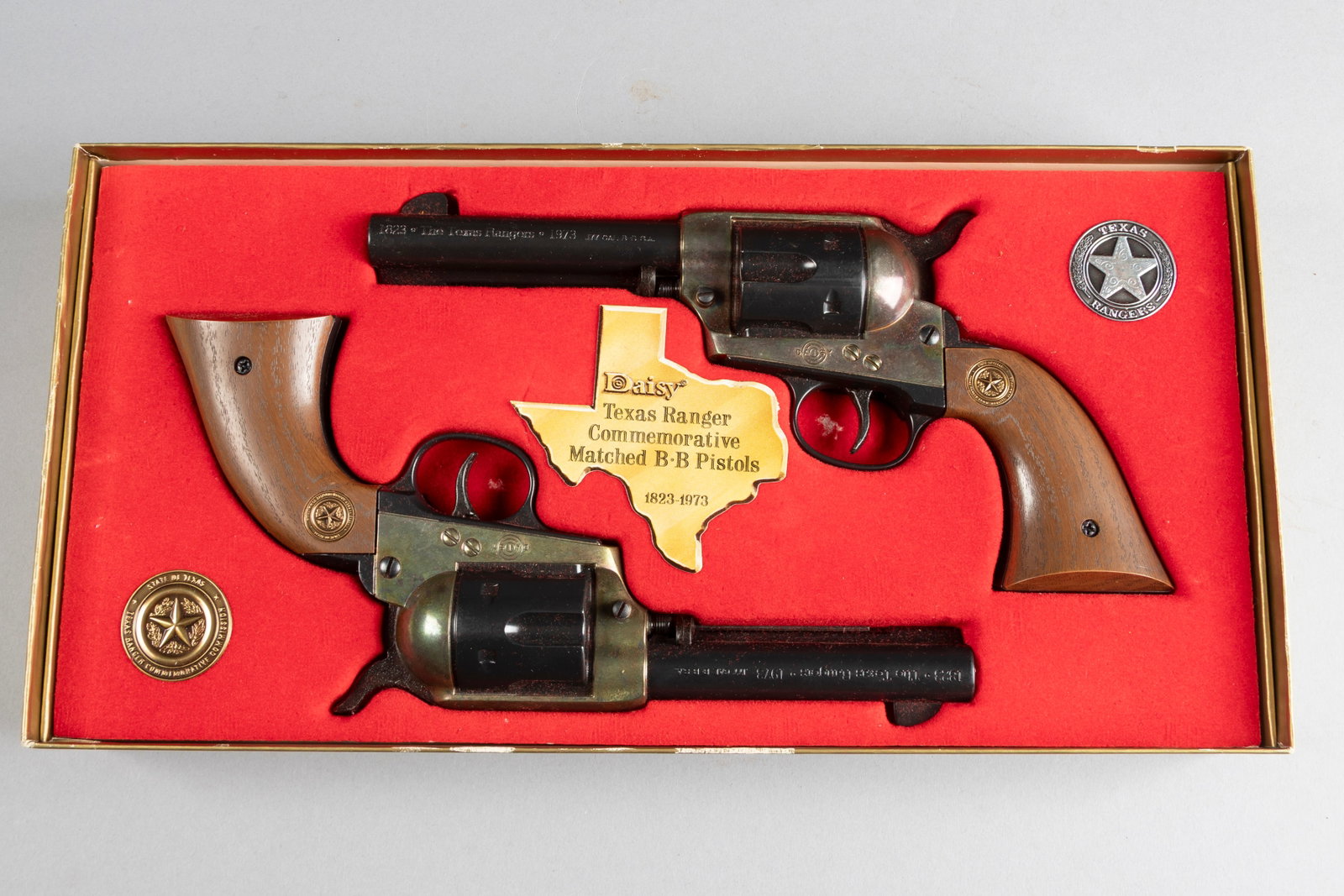 Boxed pair of Daisy Texas Ranger Commemorative BB Pistols. Commemorating 1823-1973, .177 caliber: Boxed pair of Daisy Texas Ranger Commemorative BB Pistols. Commemorating 1823-1973, .177 caliber single actions in their original fitted picture box, complete with manual and paperwork, unused conditi