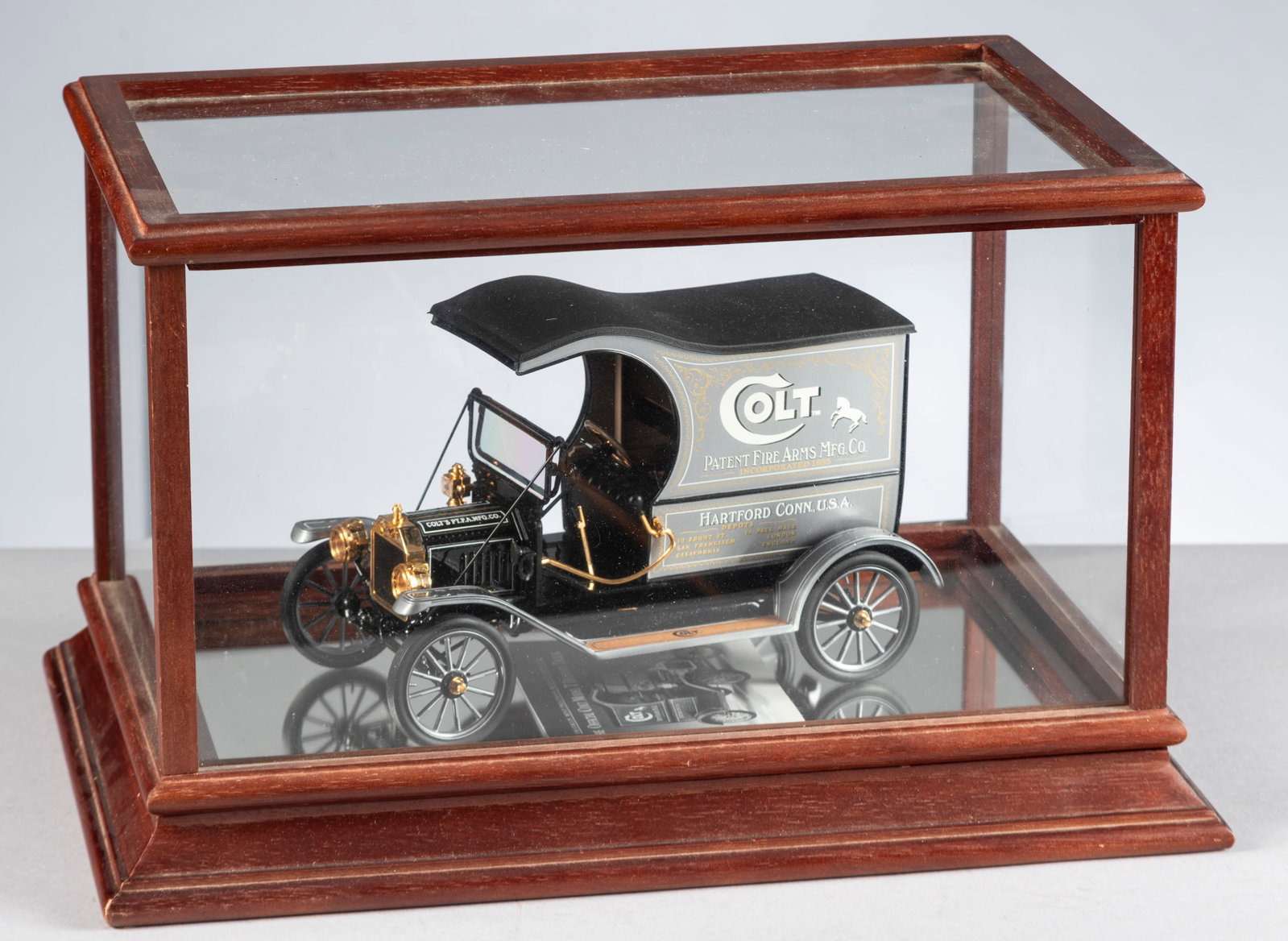 A miniature of "The Official Colt Model-T Delivery Truck", with its original glass & wooden: A miniature of "The Official Colt Model-T Delivery Truck", with its original glass & wooden Showcase. Model-T measures 8 1/2" L x 5 1/2" T x 4" W. Incredible detail, even has hinged rear doors and is 