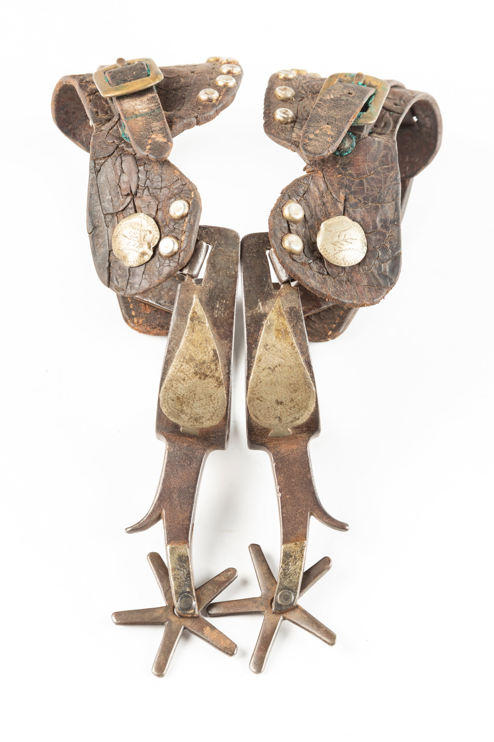 Pair of unmarked Crockett Spurs, single mounted, big leaf pattern, #157 with chap guards. Sold with: Pair of unmarked Crockett Spurs, single mounted, big leaf pattern, #157 with chap guards. Sold with a pair of fragile vintage two-piece straps. Maples Estate.