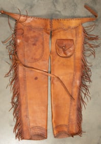Fine pair of leather Stove Pipe Style Chaps with fringed border, outside sewn pockets with leather