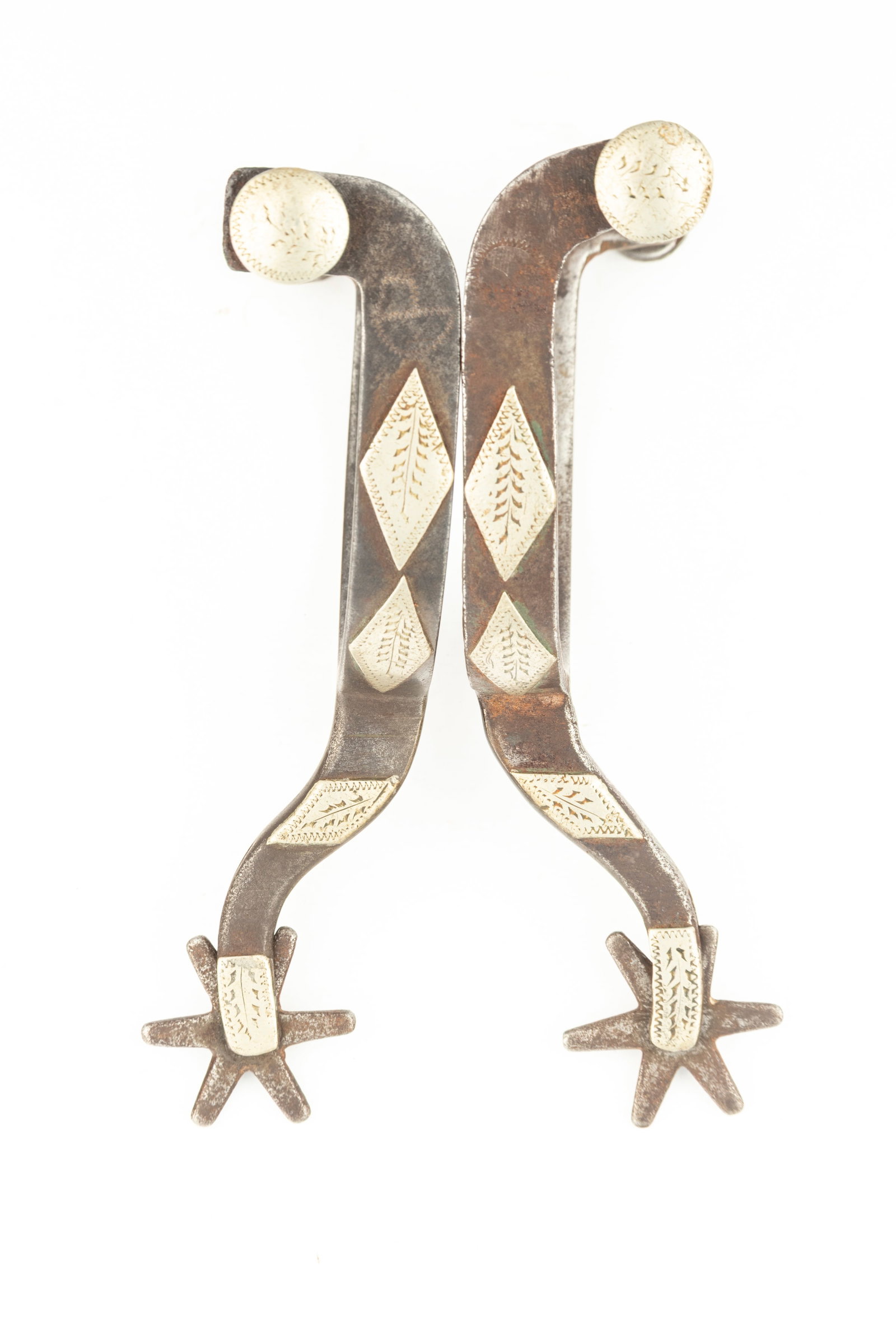 Pair of McChesney double mounted Spurs, in a variation of #14, with etched silver buttons. NOTE: One: Pair of McChesney double mounted Spurs, in a variation of #14, with etched silver buttons. NOTE: One spur has longer shank than the other, see spur book to explain. Maples Estate.