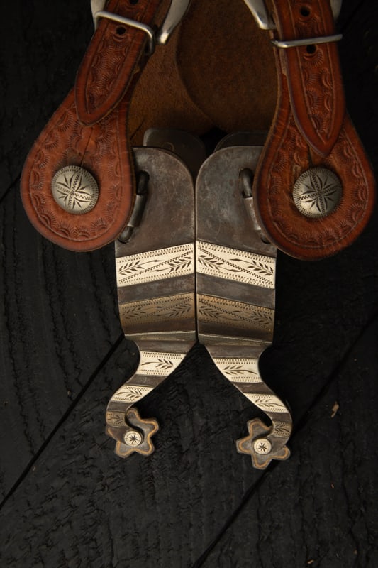 Pair of "J.D. Moss" marked single mounted Spurs, #144, with hand engraved chevrons and etched swing (1 of 2)