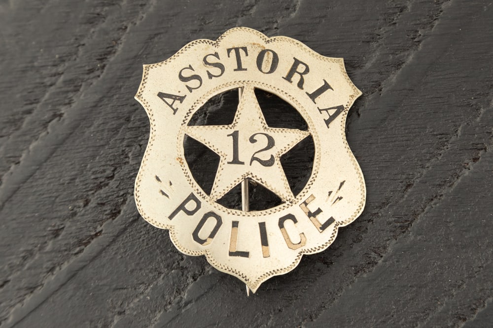 Vintage, shield shaped, cut-out 5-point star Badge marked "ASSTORIA/12/POLICE. Hallmarked on back: Vintage, shield shaped, cut-out 5-point star Badge marked "ASSTORIA/12/POLICE. Hallmarked on back "MITCHELL MFG. CO./BOSTON". Has nice saddle pin and catch, measures 2" T x 1 3/4" W. Estimate $400-$60