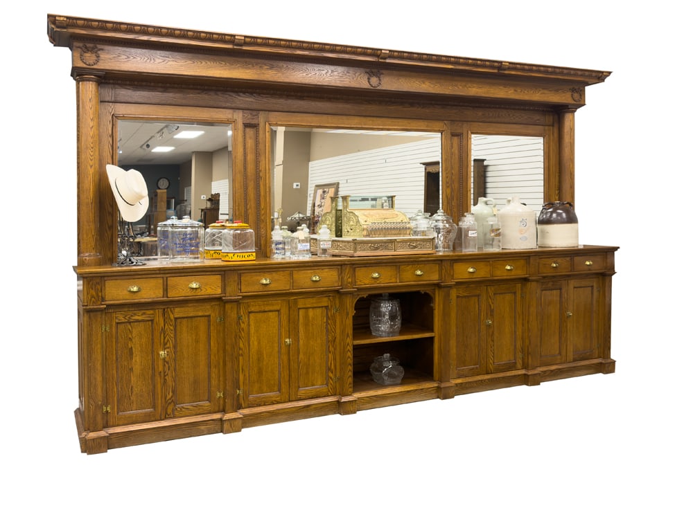Antique 14 ft. two-piece, oak Saloon Back Bar, circa 1890-1900, with three beveled mirrors and: Antique 14 ft. two-piece, oak Saloon Back Bar, circa 1890-1900, with three beveled mirrors and carved crest. Lower portion has 10 storage drawers and 8 blind doors. Back Bar measures 14 ft 2" L x 8 ft
