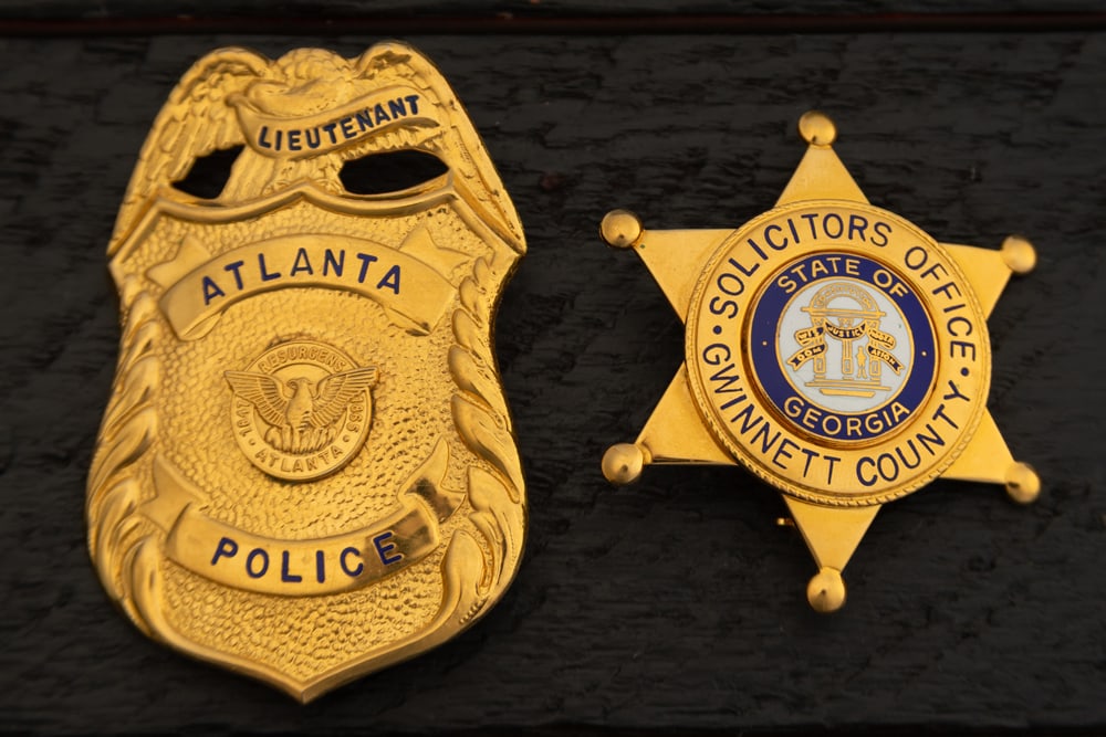 This lot consists of two Badges to include: (1) Large vintage gold tone Shield shaped Badge with (1 of 2)