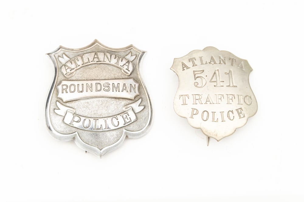This lot consists of Two (2) Badges to include:(1)Vintage large Shield Badge marked “ATLANTA/ (1 of 2)
