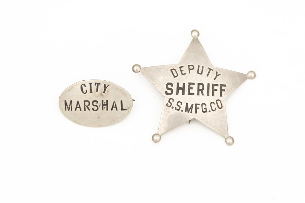 This lot consists of Two (2) Badges to include: (1) Small vintage oval Badge marked “CITY/: This lot consists of Two (2) Badges to include: (1) Small vintage oval Badge marked “CITY/ MARSHAL”, possibly a lapel or Cap Badge. Minor wear with most all soft black enamel intact, has small