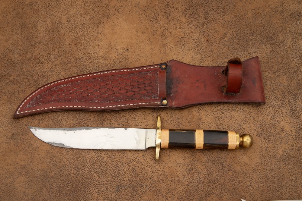 Clip Point Bowie in leather sheath, possibly horn handle, heavy brass cross guard with brass ball (1 of 2)