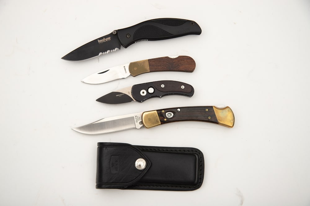 This lot will consist of four (4) Lock Blade Folding Knives to include: (1) "BUCK" marked Switch: This lot will consist of four (4) Lock Blade Folding Knives to include: (1) "BUCK" marked Switch Blade Knife with leather scabbard, when open is 8 1/2" long. (2) "KERSHAW" marked Lock Blade Knife, SN