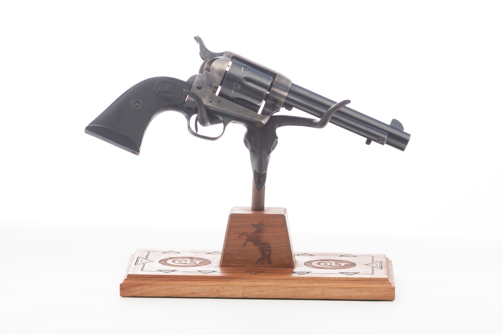 Custom Wooden Pistol Stand with Steer Head, measures 10" L x 5" W x 8" T to tip of horn. The word: Custom Wooden Pistol Stand with Steer Head, measures 10" L x 5" W x 8" T to tip of horn. The word "COLT" embossed on floor plate. Revolver Not Included.