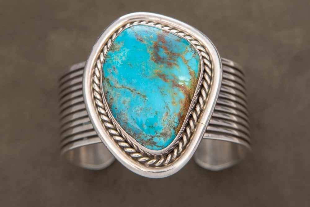Beautiful and ornate wide band Cuff, maker marked "RLG / 925 Silver / Rodney Lee Gueno", 1 1/4" wide: Beautiful and ornate wide band Cuff, maker marked "RLG / 925 Silver / Rodney Lee Gueno", 1 1/4" wide band, mounted with a large turquoise stone in silver mounting, marked "925".