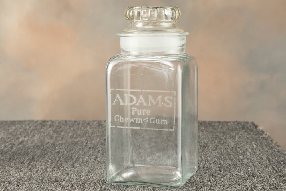Antique glass Advertising Jar for "Adam's Pure Chewing Gum", advertisement is etched in the front: Antique glass Advertising Jar for "Adam's Pure Chewing Gum", advertisement is etched in the front panel of this jar. Measures 11 1/2" T x 5" sq. with ground stopper.