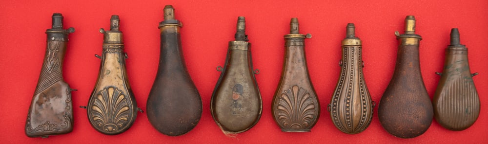 Collection of eight (8) antique leather & brass Powder Flasks sold as a collection that vary in size (1 of 2)