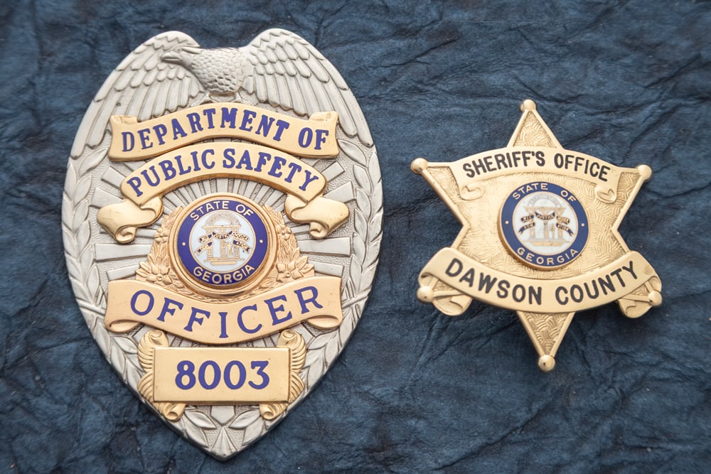 This lot consists of two Badges to include: (1) Gold tone modern 6-point Ball Star Badge marked (1 of 2)