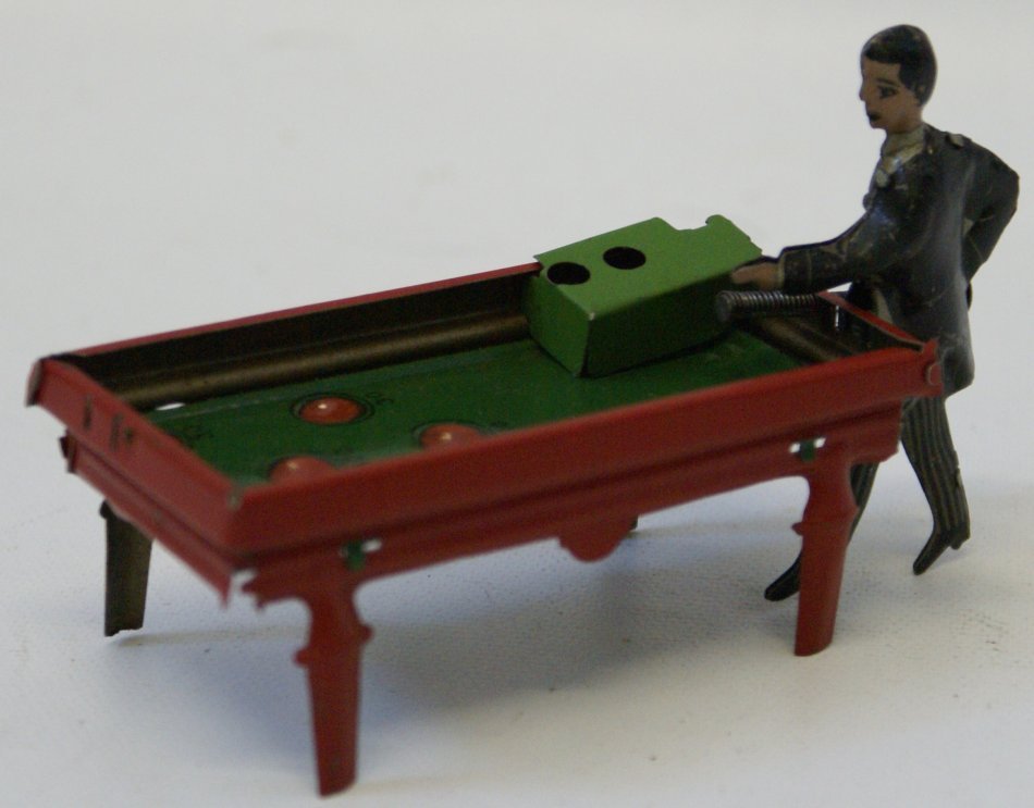 German 1920's Tin Penny Toy Billiard Pool Player,: German 1920's Tin Penny Toy Billiard Pool Player, spring loaded action for shooting. Cute little piece. Measures 4" long. Figure is 2-1/2" tall. Very nice lithography.