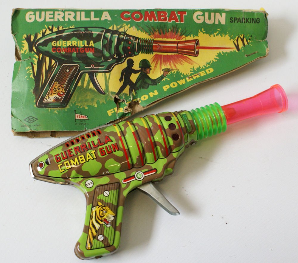 Tin Friction Sparkling Guerrilla Combat Gun, Yoshiya KO: Vintage Tin Friction Sparkling Guerrilla Combat Gun in original box. Made by Yoshiya (KO) Japan for Flare Toys. Marked 8-2683. Fabulous tin plate lithography! Very hard to find model! Gun measures 9-3