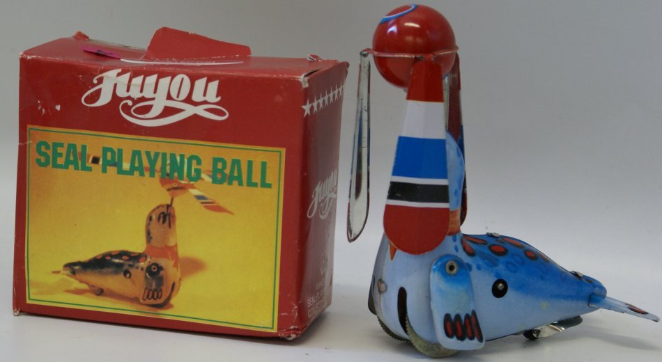 Tin Litho Windup SEAL PLAYING BALL Juyou JMT24, mint in: Tin Lithographed Wind up SEAL PLAYING BALL with key, Juyou JMT 24, 6" tall, mint in original box, made in China. Unused and not displayed. Untested. As is.