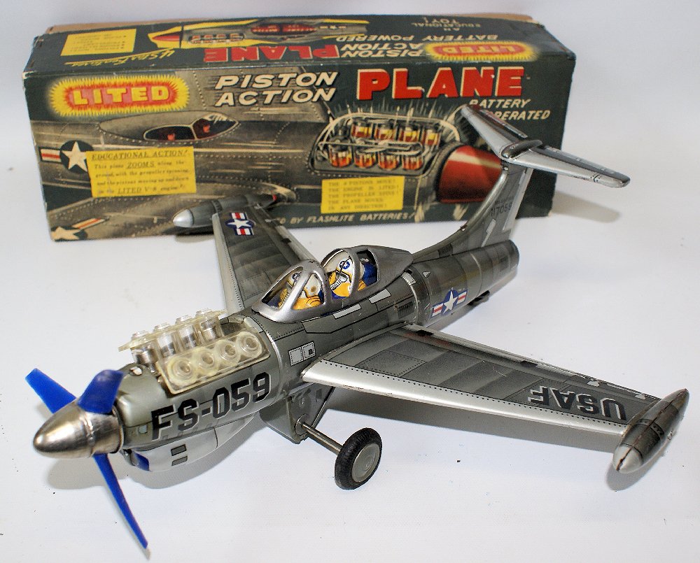 50s Tin USAF Battery Op LITED PISTON ACTION PLANE: Vintage 1950's Tin Lithographed US Air Force 117059 Battery Operated LITED PISTON ACTION PLANE Airplane by Showa, Japan. LN condition in the original box with inserts. 14" long. Has removeable wings. 