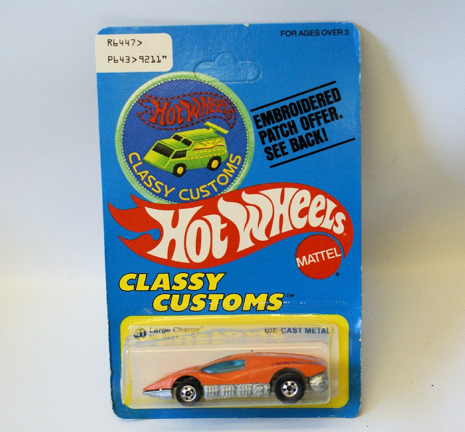Vintage 1977 HOT WHEELS 41 LARGE CHARGE Car No. 9211,: Vintage 1:64 Scale Diecast Metal 1977 HOT WHEELS Classy Customs 41 LARGE CHARGE Car No. 9211, on the original UNPUNCHED card. Orange car with purple details. Has some creasing on the card. Blister pac