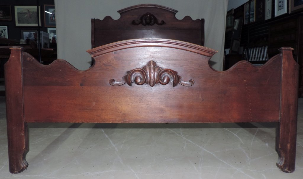 Antique Full Wooden Bed Frame: Solid mahogany antique bed frame. The designs at the head and foot boards are hand carved. This piece is in fair condition with some nicks and scratches. Frame measures 80" x 55" with a head board hei