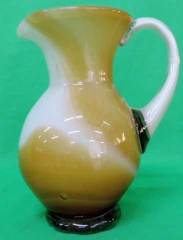 Hand Blown Glass Pitcher This is a beautifully hand: This is a beautifully hand blown pitcher. The way the artist pulled and swirled the colors during the process has created a creamy caramel affect.