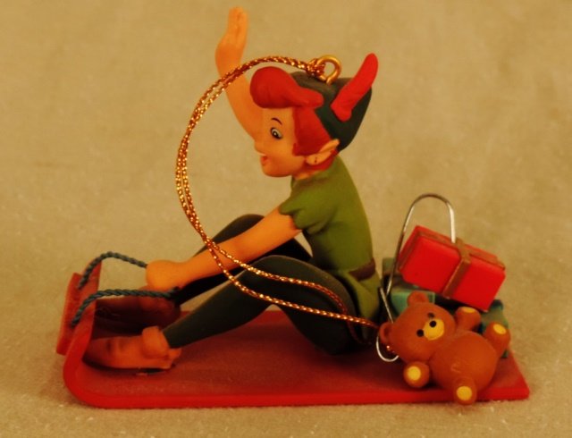 Disney's Peter Pan: Disney's Peter Pan is riding a sled.