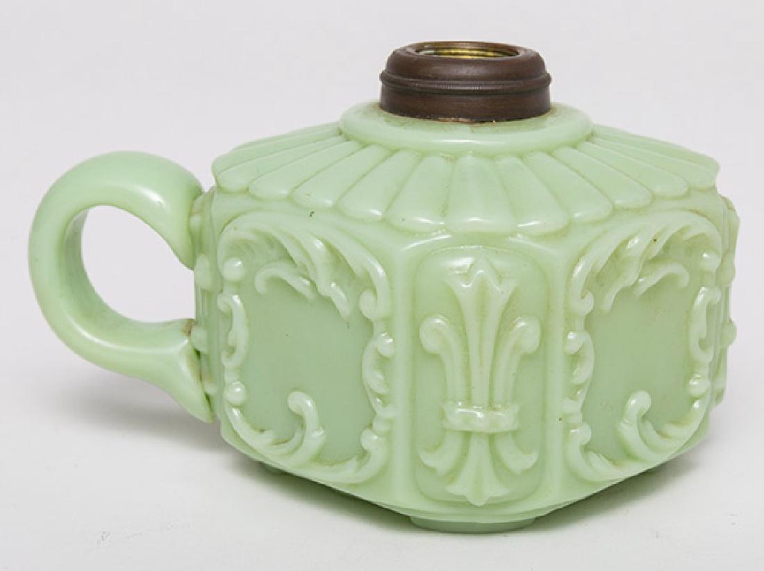 Green Milk Glass Finger Lamp: Mold blown with stop ribbed top, floral scrolled sides and inset stepped foot, applied "C" scroll handle, brass collar, 4" square x 3 1/4" high.