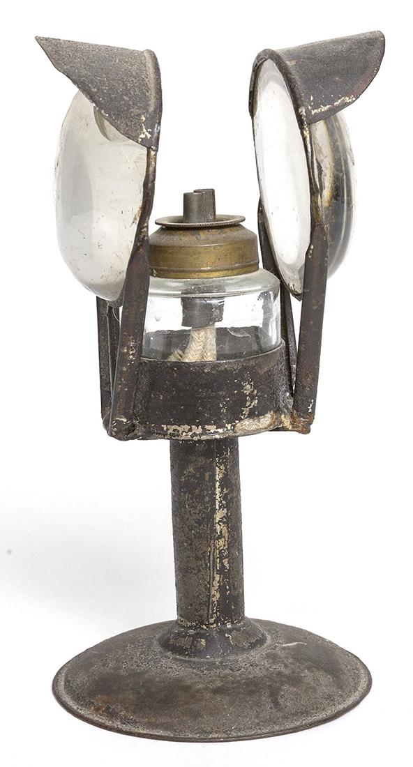 Tin Whale Oil Magnification Lamp: With domed hog scrapper base, straight column and cylindrical dish in which a blown glass font with brass collar & double spouts rests, flanked by two fixed hooded magnification lenses with traces of 