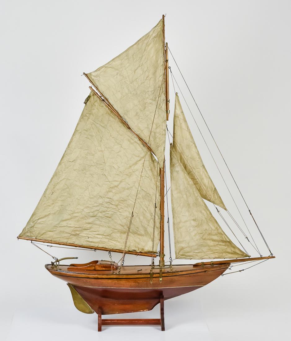 Outstanding Early Pond Schooner: Beautifully made in hardwoods, fully rigged with brass fittings, single mast with four original cloth sails, inlaid banding at sides, including upper band in ebony and lower band in whale bone with ne