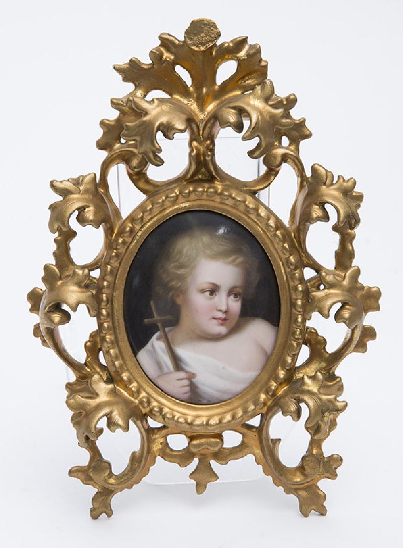 Porcelain Plaque St. John the Baptist: Child image of the Saint holding a wood cross, oval, stamped E on back,Porcelain 2 1/2 x 3 1/4" in carved and gilt rococco wood frame, 5 1/2 x 8".