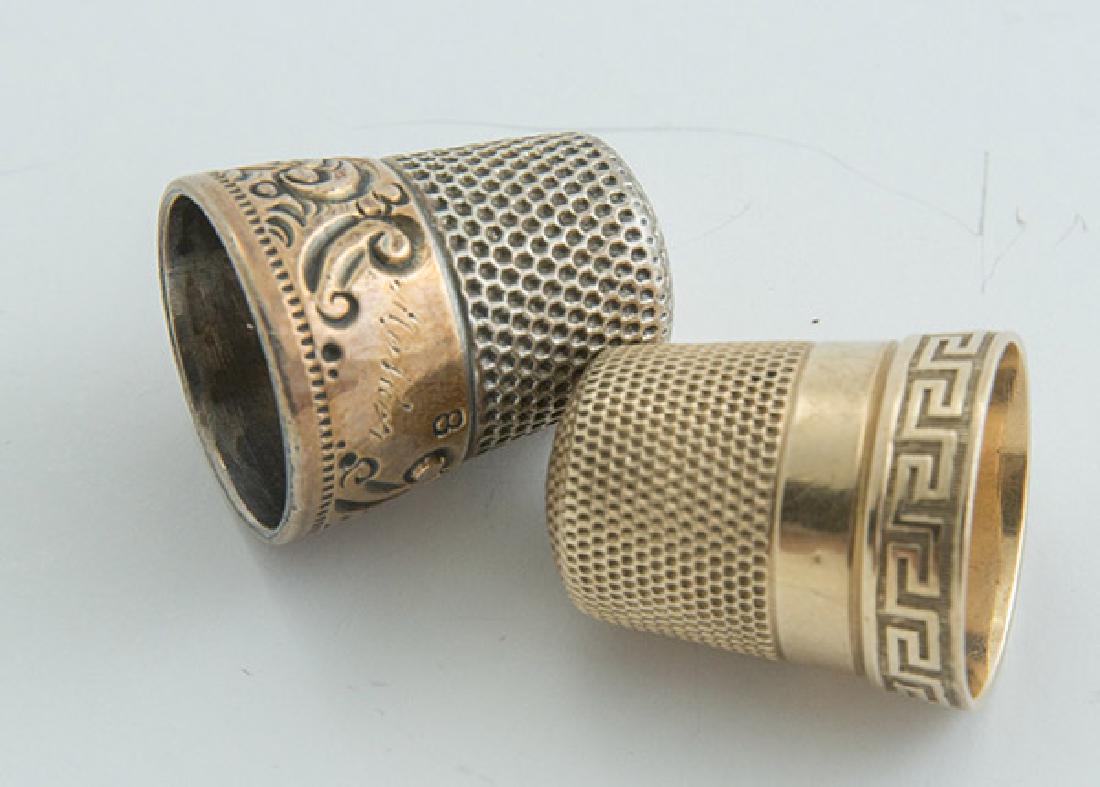 Gold & Silver Thimbles: Lot of two including a number nine gold thimble, with makers mark, circa 14K gold, weight 3 grams; and sterling with gold band, weight 0.20 ozt.