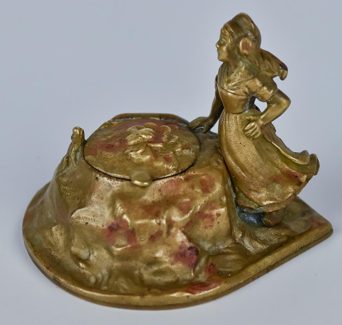 Bronze Figural Inkwell: Full figure of young Dutch girl at side of flower strewn rock with frog at edge. Hinged bronze lid with original glass liner, unmarked, 3 x 2 3/4 x 2 1/2" high.