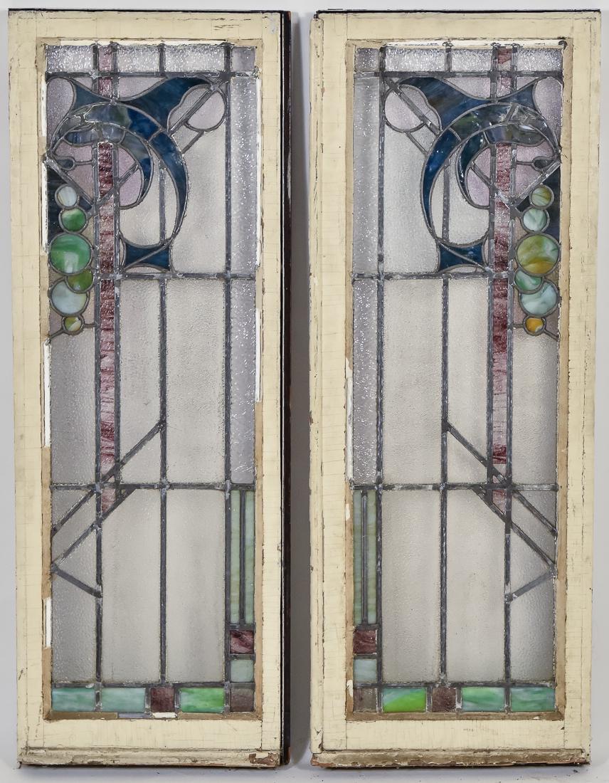 Pair of Arts & Crafts Stain Glass Windows: Leaded, circa 1900 with scrolled geometric design and Frank Lloyd Wright inspired circles on clear pebbled ground in various color and slag glass, set in original wooden frames, each 19 1/2 high x 51