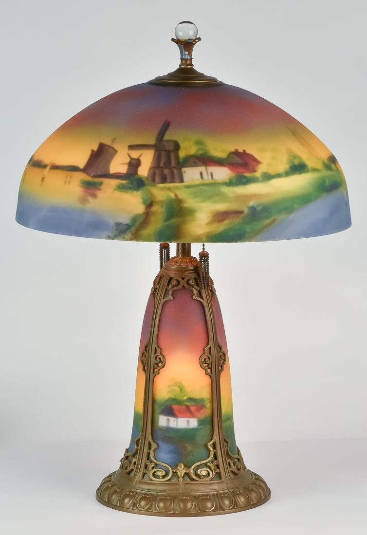 Pittsburgh Reverse Painted Table Lamp: Beautiful lamp with pebbled finished shade with landscape scene with windmills, and lake with sailboats on 17" diameter shade, with original base with lighted landscape scene with cottages, in bronzed