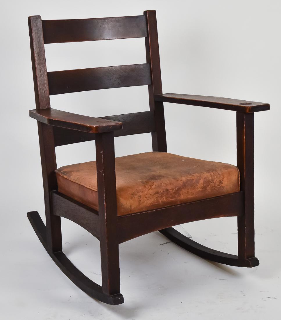 Charles Stickley Arm Rocker: Oak, with three vertical slat back, arched stretchers with original brown leather seat, signed on back, good dark original finish, very good condition, 34" high x 27" wide x 31" deep, seat at 17".