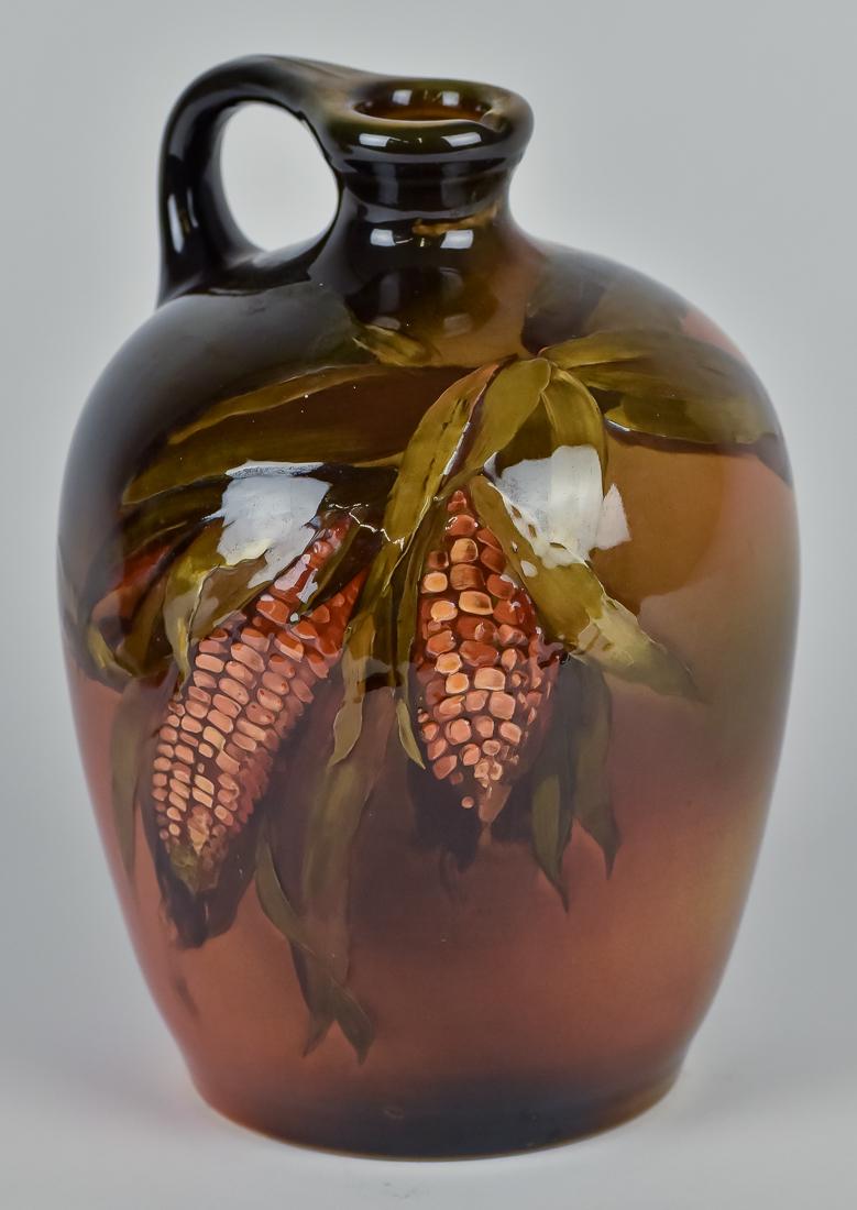 Rookwood Standard Glaze Whiskey Jug: Polychrome painted with two partially husked ears of maize, made for corn whiskey with spout and C scroll handle, marked on base with Rookwood mark with nine flames above for the year 1895, shape numb