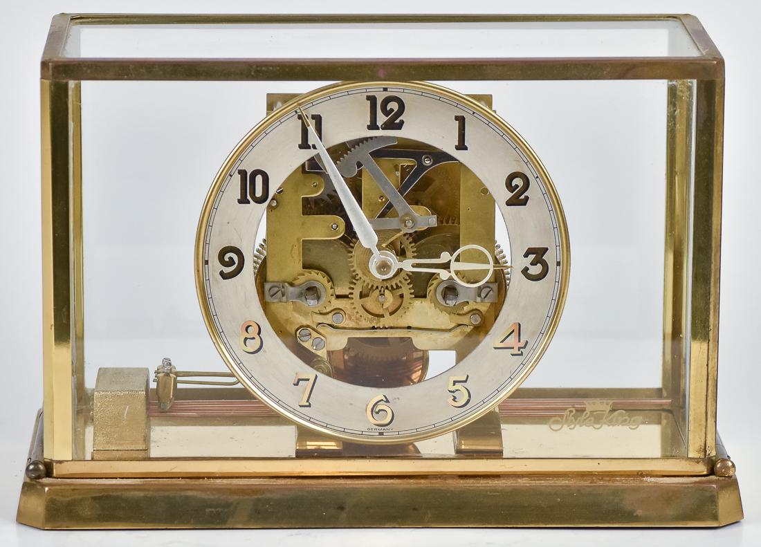 German Style King Mid-Century Clock: Brass and glass case with open silvered dial with Arabic numerals, brass spring driven time & strike movement, marked Germany and decal on glass with crown over Style King, 11 1/2 x 5 1/2 x 7 5/8" hig