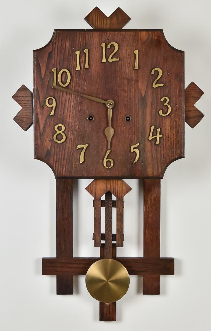 Arts & Crafts Oak Wall Clock: Square dial with cut corners, applied gold painted wooden Arabic numerals, exposed pendulum, in old cleaned finish. Brass spring driven time & strike movement, 17 x 4 1/2 x 28" high.